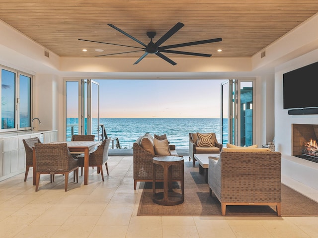 interior space featuring an outdoor living space with a fireplace and ceiling fan