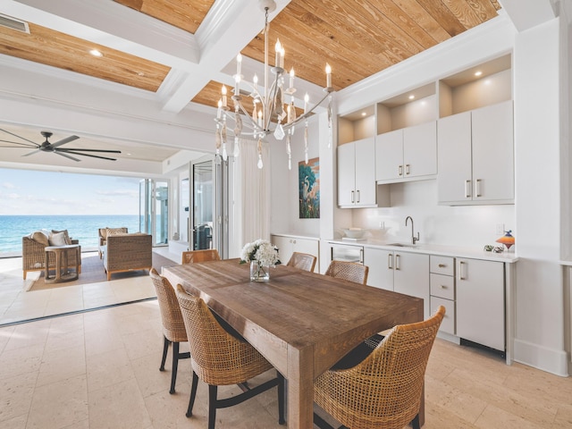 dining area featuring beamed ceiling, ornamental molding, coffered ceiling, ceiling fan, and a water view