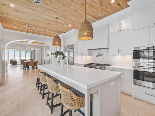 kitchen featuring a kitchen island with sink, wooden ceiling, and custom range hood