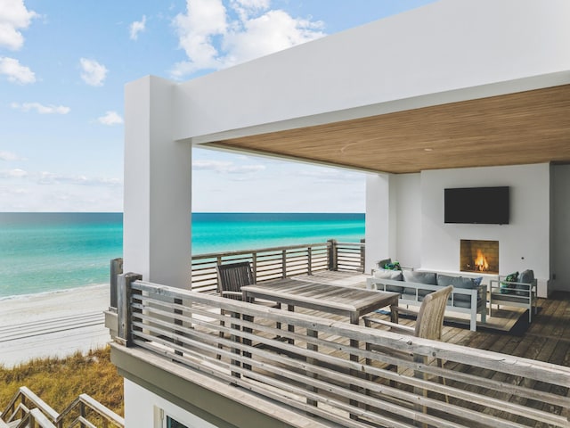 exterior space featuring a water view, an outdoor living space, and a beach view