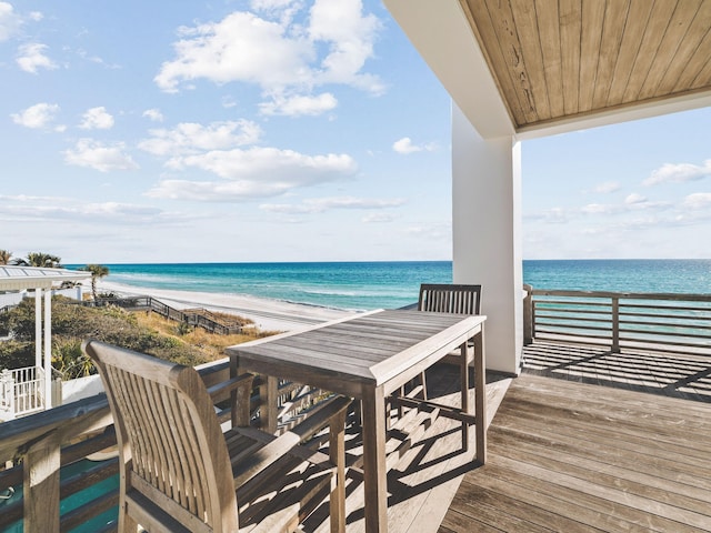 balcony with a water view and a view of the beach