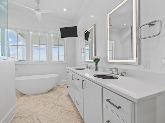 bathroom with ornamental molding, a washtub, vanity, and ceiling fan