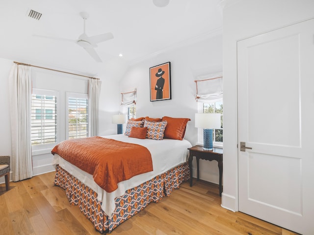 bedroom with crown molding, ceiling fan, vaulted ceiling, and light hardwood / wood-style floors