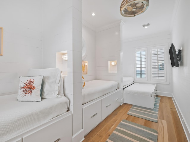 bedroom with ornamental molding and light wood-type flooring