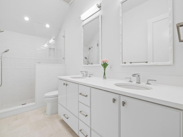 bathroom featuring tiled shower, vanity, toilet, and tile patterned floors