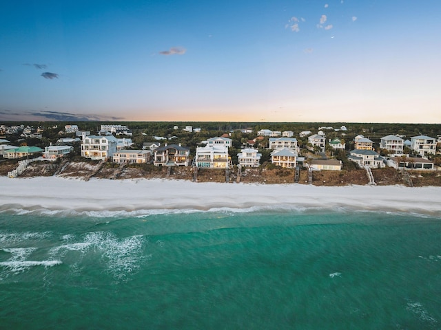 aerial view at dusk featuring a water view