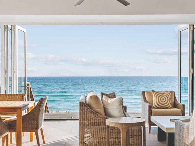 balcony with a patio, a water view, and ceiling fan