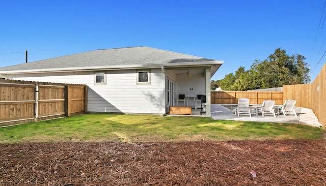 rear view of property with a lawn and a patio