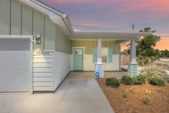 exterior entry at dusk with a garage and covered porch