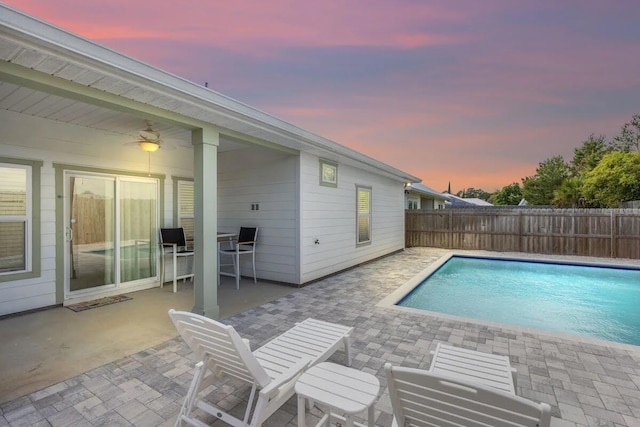 pool at dusk with a patio