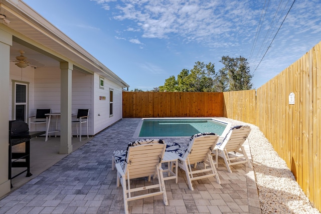 view of swimming pool featuring ceiling fan and a patio area