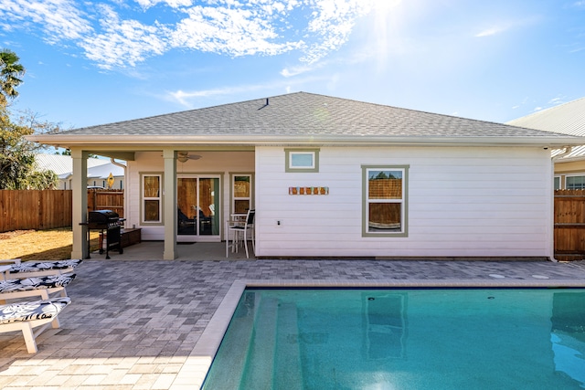 rear view of property featuring ceiling fan, a fenced in pool, and a patio