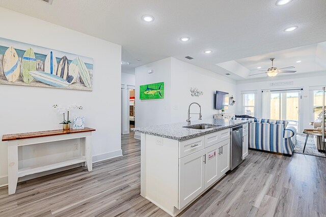 kitchen with white cabinetry, a center island with sink, dishwasher, light hardwood / wood-style flooring, and sink