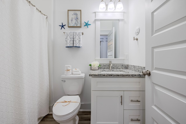 bathroom with hardwood / wood-style flooring, toilet, and vanity