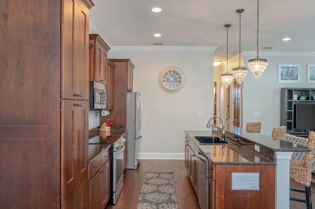 kitchen with sink, a notable chandelier, decorative light fixtures, a breakfast bar area, and appliances with stainless steel finishes