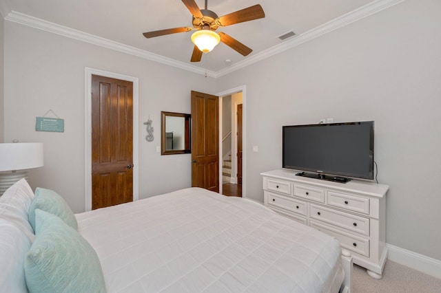 carpeted bedroom featuring ceiling fan and ornamental molding