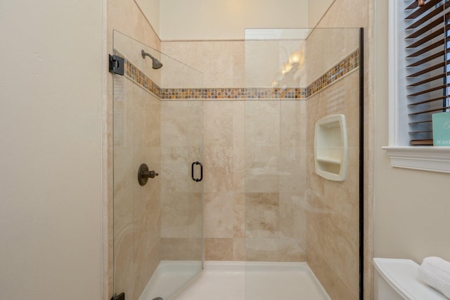 bathroom with toilet and a shower with shower door