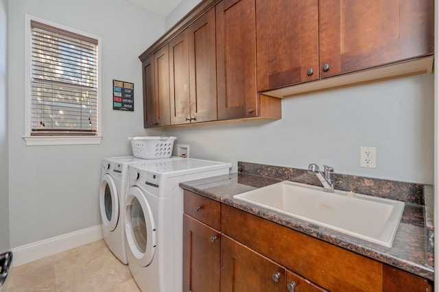 washroom featuring washing machine and clothes dryer, sink, light tile patterned floors, and cabinets