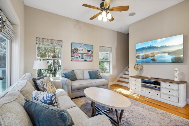 living room with ceiling fan, plenty of natural light, and light hardwood / wood-style flooring