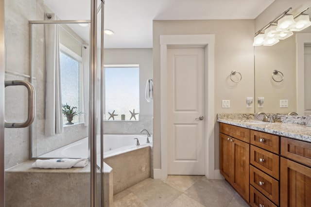 bathroom featuring tiled bath and vanity