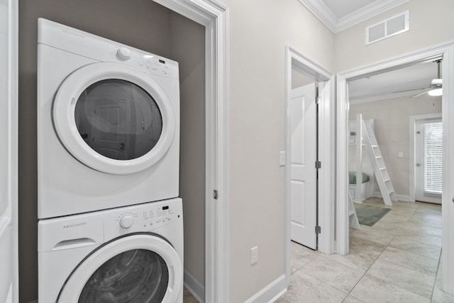 laundry room featuring stacked washing maching and dryer, ceiling fan, crown molding, and light tile patterned flooring