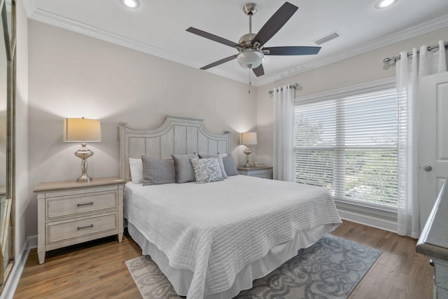 bedroom with hardwood / wood-style flooring, ceiling fan, and crown molding