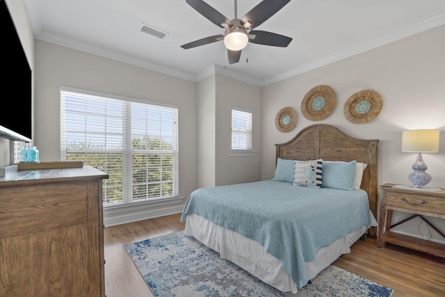 bedroom featuring ceiling fan, crown molding, and light hardwood / wood-style floors