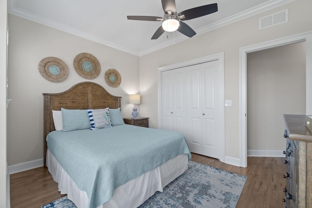 bedroom with ceiling fan, a closet, hardwood / wood-style floors, and ornamental molding