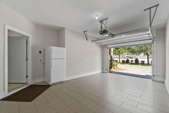 garage featuring white fridge and a garage door opener