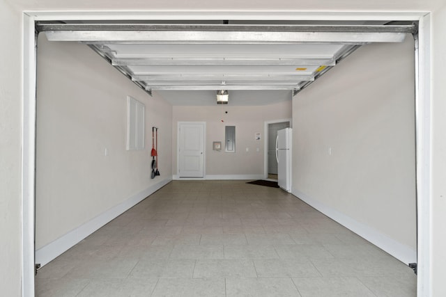 garage featuring electric panel and white refrigerator