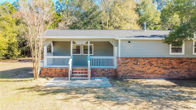 view of front of home featuring a porch and brick siding