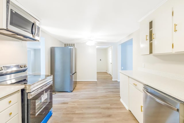 kitchen featuring light wood-type flooring, white cabinets, stainless steel appliances, and light countertops