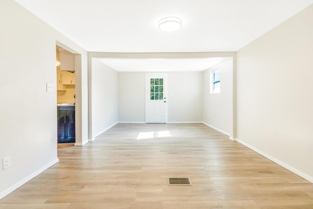 unfurnished room with light wood-type flooring, baseboards, and visible vents