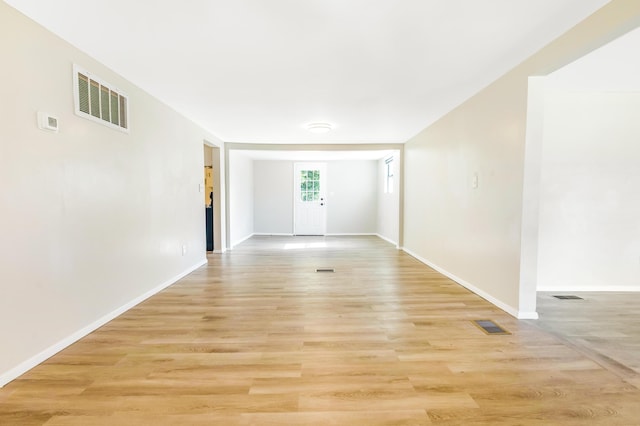 unfurnished room with light wood-style floors, visible vents, and baseboards