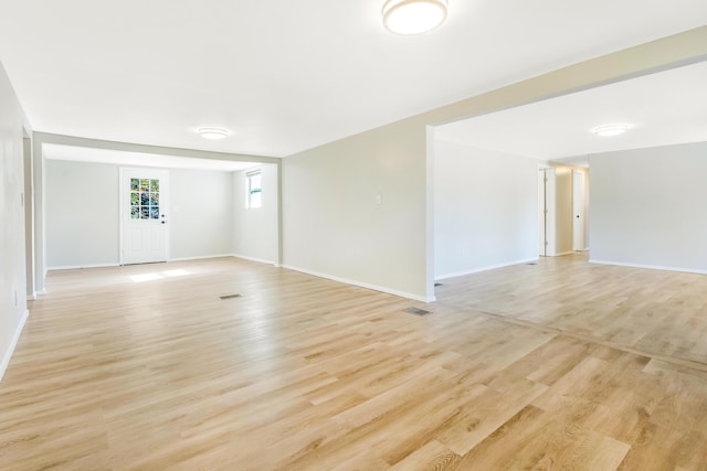 spare room featuring light wood-style floors, visible vents, and baseboards