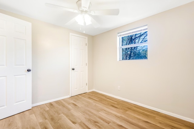 unfurnished bedroom featuring light wood-type flooring, baseboards, and a ceiling fan