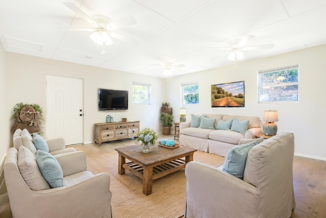 living area featuring ceiling fan, light wood-type flooring, attic access, and baseboards