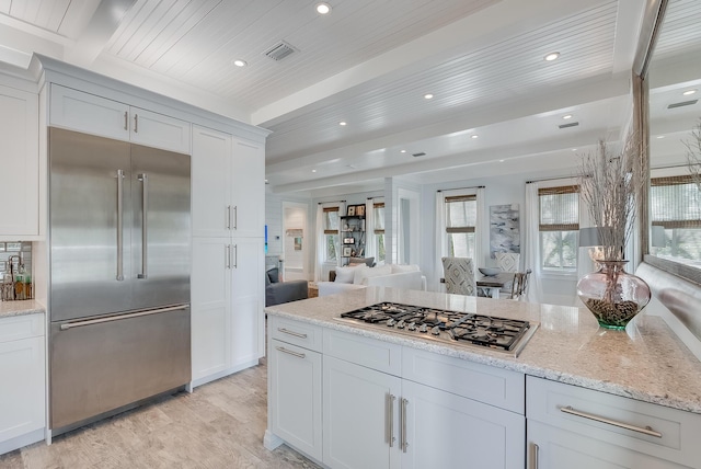 41 Tresca Lake Ct, Santa Rosa Beach, FL 32459 - kitchen featuring stainless steel appliances, light wood-style floors, white cabinets, light stone counters, and beamed ceiling