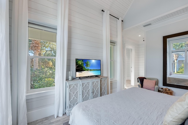 bedroom featuring wooden ceiling, light hardwood / wood-style floors, vaulted ceiling, and multiple windows