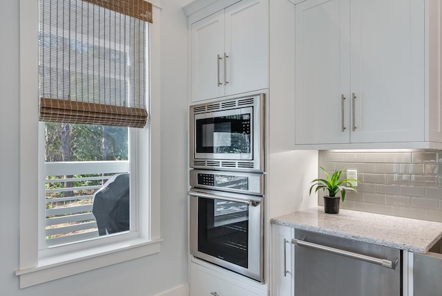 41 Tresca Lake Ct, Santa Rosa Beach, FL 32459 - kitchen with appliances with stainless steel finishes, decorative backsplash, white cabinetry, and light stone countertops