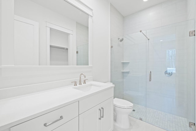 bathroom with a stall shower, vanity, and toilet