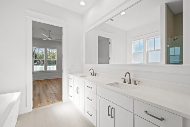 full bathroom featuring a bathtub, tile patterned flooring, a sink, and double vanity