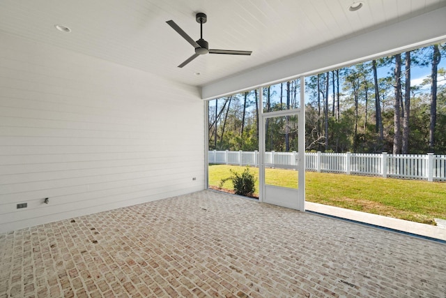 unfurnished sunroom featuring a ceiling fan