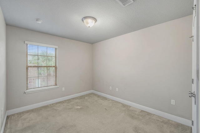 carpeted empty room with a textured ceiling