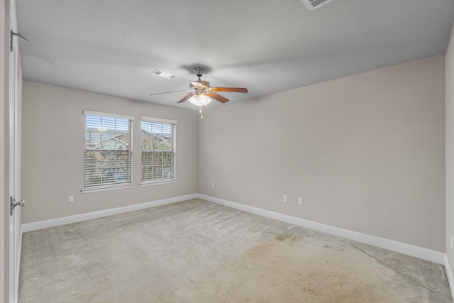 spare room with a textured ceiling, ceiling fan, and carpet floors