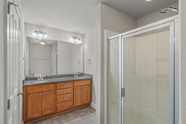 bathroom with a textured ceiling, an enclosed shower, and vanity