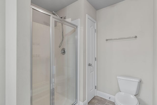 bathroom with tile patterned floors, toilet, and an enclosed shower