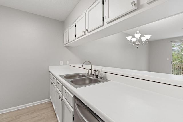 kitchen with sink, pendant lighting, light hardwood / wood-style flooring, white cabinets, and a chandelier