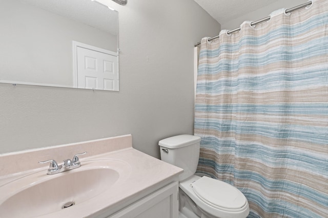 bathroom featuring vanity, a textured ceiling, toilet, and curtained shower