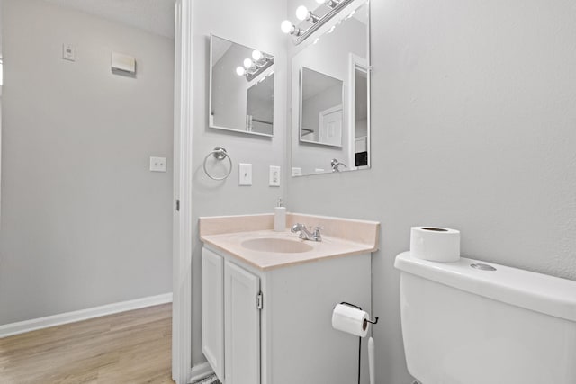 bathroom featuring hardwood / wood-style flooring, vanity, a textured ceiling, and toilet